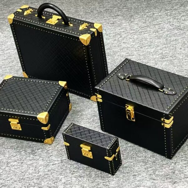 Black croc-embossed hard case set with gold trunk hardware - corner protectors, clasps and handles by Maya Metal