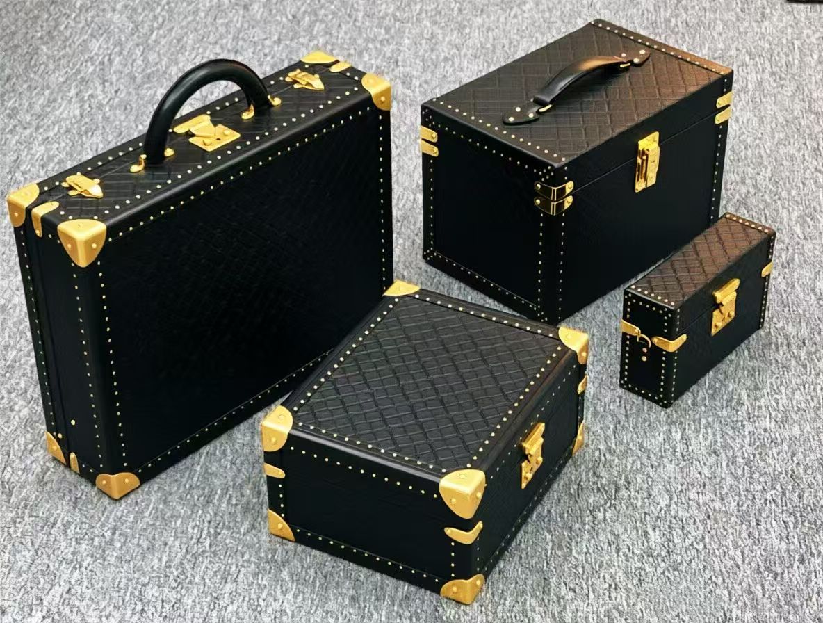 Gold case corners, clasps and stud trim on black hard trunk cases